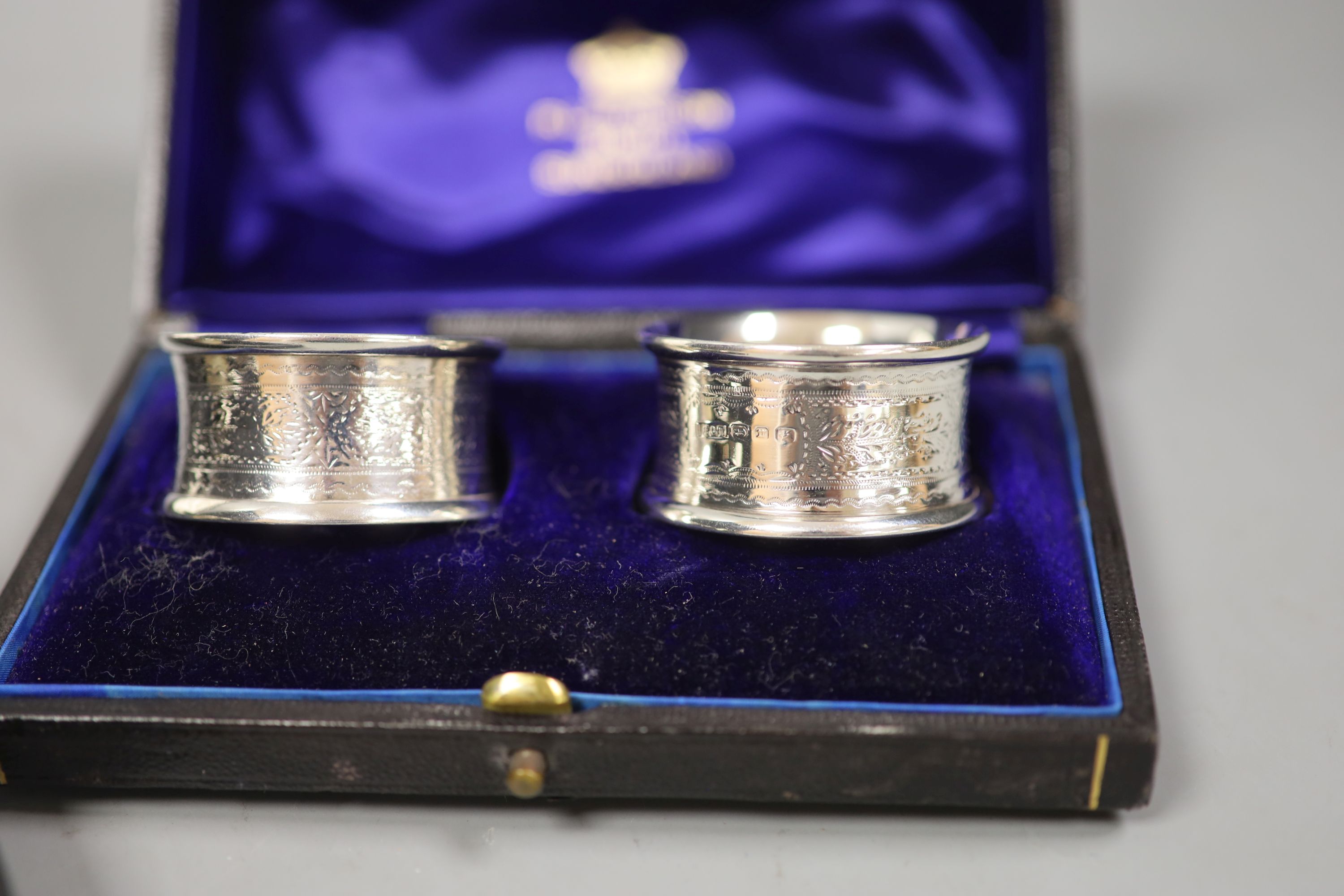 A cased christening dish with associated pusher and spoon, together with a cased pair of silver napkin rings.
